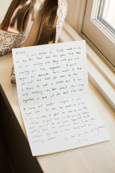 a handwritten note next to a pair of high heeled shoes on a window sill