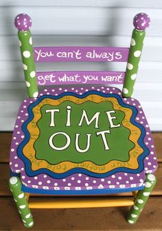 a purple and green chair with the words time out painted on it