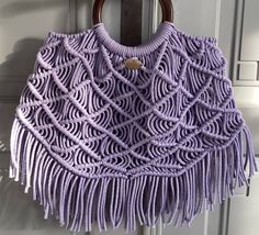 "Step out in style with this beautiful boho chic macrame handbag! This unique purse is designed to catch attention - the round handles add elegance and the fringe bottom accentuates the playfulness of the bag. Under your arm, this bag feels like a dream, being both practical and spacious enough to carry your everyday essentials. Elevate your style with this exquisite macrame handbag and shine brightly every day! Reasons to choose this bag: 1. Statement Piece: Stand out from the crowd with this e Bohemian Purple Crochet Bag For Everyday Use, Handmade Bohemian Purple Crochet Bag, Bohemian Crochet Bag With Macrame For The Beach, Bohemian Crochet Bag With Macrame For Vacation, Bohemian Crochet Macrame Bag, Bohemian Crochet Tote Bag With Macrame, Bohemian Crochet Bag With Macrame, Bohemian Crochet Bag With Braided Handles, Macrame Purse