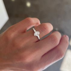 a woman's hand with a diamond ring on it