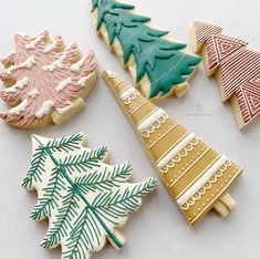 four decorated christmas cookies sitting on top of a white table next to eachother