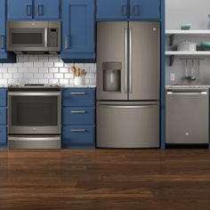 a kitchen with blue cabinets and stainless steel appliances, including an oven, refrigerator, microwave, dishwasher and stove