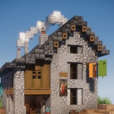 a house made out of rocks and stones with lots of windows on the top floor