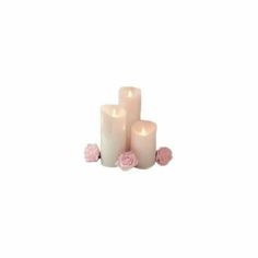 three white candles with pink roses on the bottom and one candle in the middle, sitting next to each other