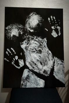 a black and white painting with hand prints on it