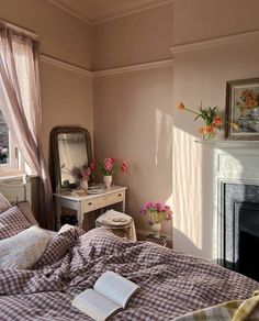 a bedroom with a bed, dresser and mirror in it next to a fire place