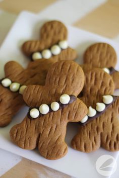 some cookies that are shaped like animals on a plate with white frosting and chocolate