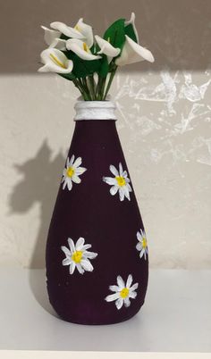 a purple vase with white flowers painted on it