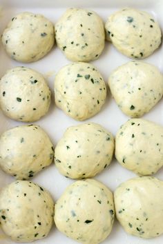 several balls of dough sitting on top of a white tray with green sprinkles