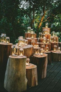 candles are sitting on wooden stumps in the woods