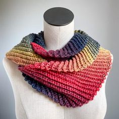 a multicolored knitted scarf on a mannequin