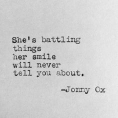 an old typewriter with the words she's battling things her smile will never tell you about