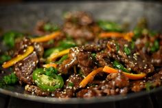 beef, peppers and carrots with sesame seeds in a wok