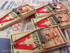 four mouse traps sitting on top of a newspaper