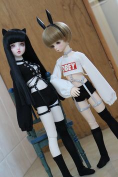 two dolls are standing next to each other