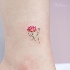 a small pink flower tattoo on the ankle