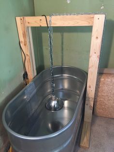 a large metal tub with a water faucet attached to the side and chains hanging from it