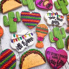 decorated cookies are arranged in the shape of heart, cactus, and taco bell