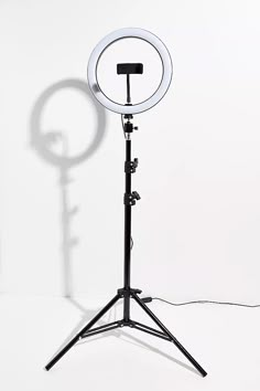 a light that is on top of a tripod with a white wall in the background