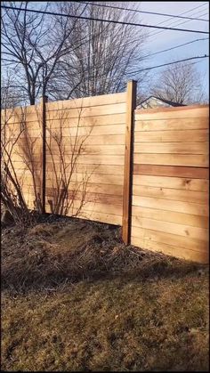 a wooden fence in the middle of a field