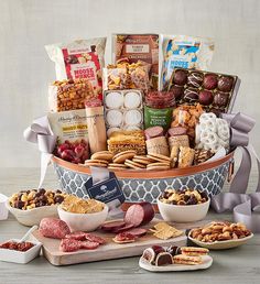 the ultimate gourmet gift basket is displayed on a table with other snacks and treats