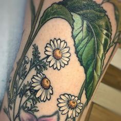 a woman's leg with flowers and leaves on it