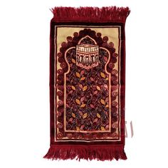 a red rug with an intricate design and fringes on the bottom, in front of a white background