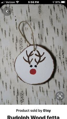 a wooden ornament with a reindeer's head on it hanging from a string