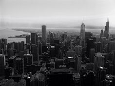 black and white photograph of city skyline with water in the background, taken from above