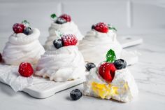 three small desserts with berries and whipped cream