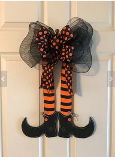 a door hanger decorated with black and orange striped stockings, polka dots and a bow