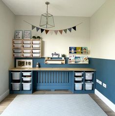 a blue and white playroom with toy bins