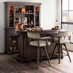 a bar with two stools in front of it and an open cabinet behind it