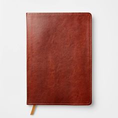 a brown leather notebook on a white surface