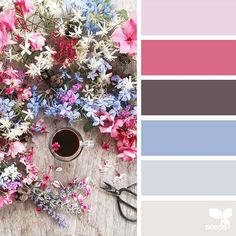 the color scheme is pink, blue, and grey with flowers in it on top of a wooden table