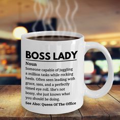 a white coffee mug with the words boss lady on it sitting on a wooden table