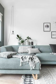 a living room with a blue couch and potted plants