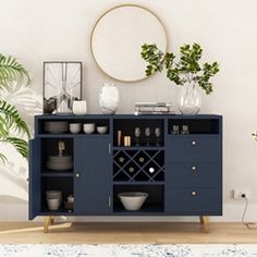 a blue cabinet with wine glasses and plates on it next to a potted plant