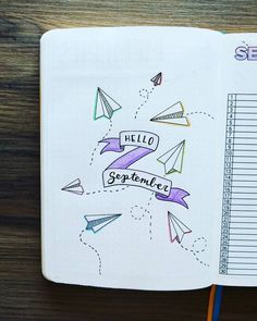 an open notebook with paper airplanes on it and the words hello september written in cursive writing