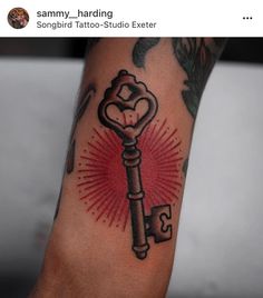 a person with a tattoo on their arm holding a key