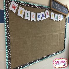 a welcome sign is hanging on the wall next to a bulletin board that says welcome