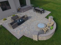 an aerial view of a patio and fire pit in the middle of a lawn area