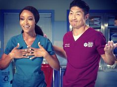 a man and woman in scrubs standing next to each other with their hands together