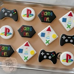 decorated cookies in the shape of video games are displayed on a cookie sheet that says game on