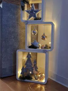 three shelves with christmas decorations and lights on them