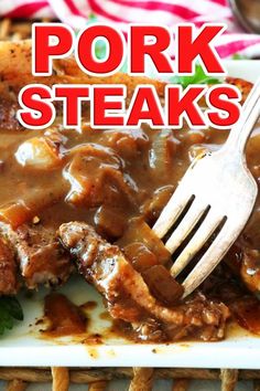 pork steaks with gravy is on a white plate and has a fork in it