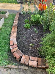 a brick garden bed with flowers in it