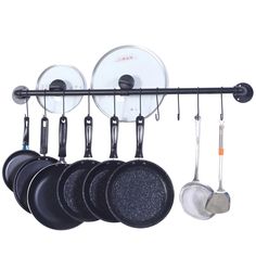 pots and pans are hanging on a rack with spoons, spatulas and other kitchen utensils