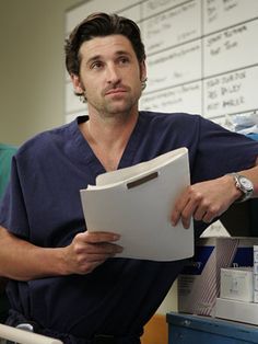 a man in scrubs is holding a folder