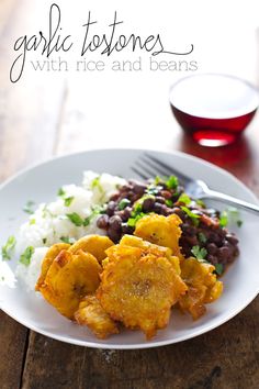 a white plate topped with food next to a glass of wine